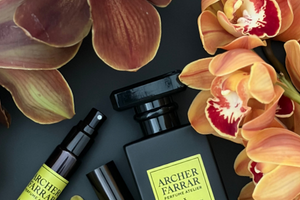 Perfume bottle obscured by brown cymbidium orchid